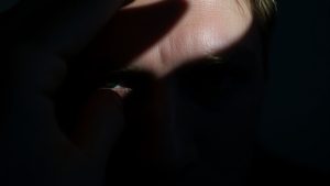 Ochi ascuns sub mână, expresie misterioasă.