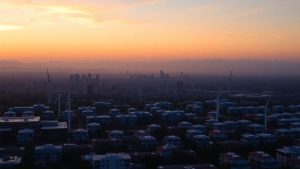 Oraș modern cu turbine eoliene și panouri solare.